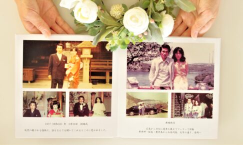 自分史として制作された写真集を手に持つ様子